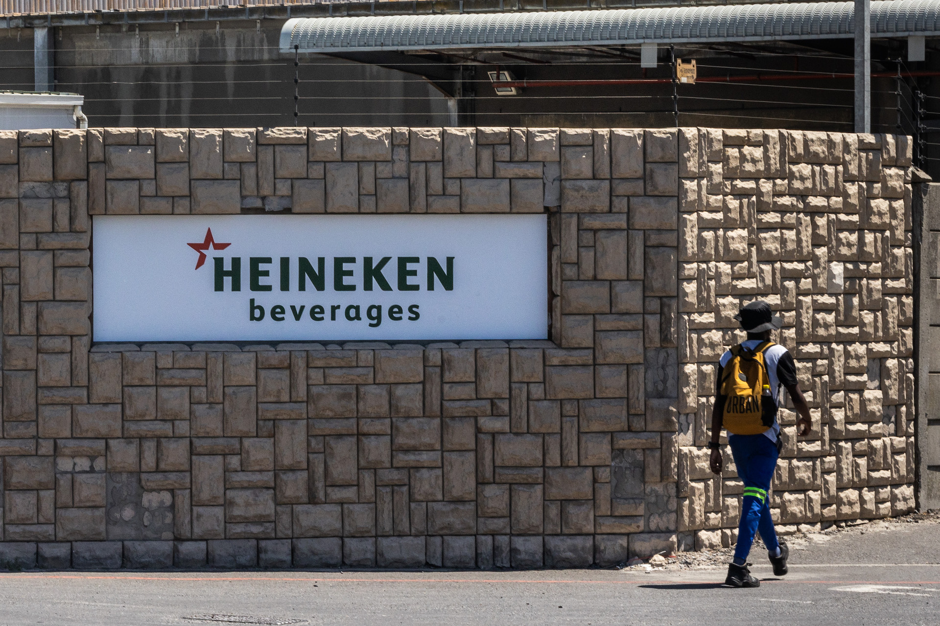 Man walks past entrance to heineken-Distell